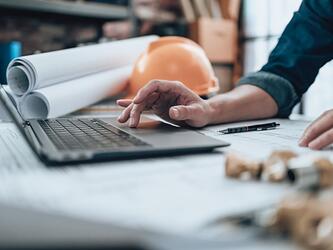 Person working employee laptop helmet labour dec25_crop